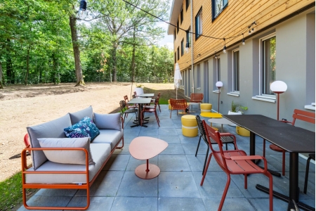 Espace extérieur avec mobilier de jardin coloré et terrasse moderne dans un environnement boisé